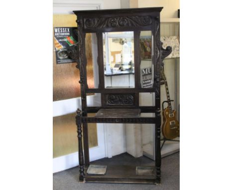 Late 19th century Dark Oak Carved Hall Stand comprising Central Mirror, Six Turned Peg Hooks, Glove Drawers and Two Stick Sta