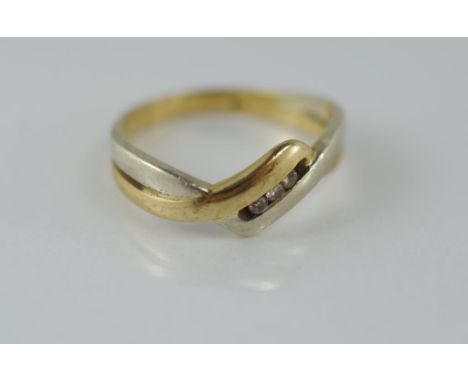 A two tone gold and diamond ring with three small channel set diamonds, marked 375, weighing approx 2.25 grams, size K1/2/5-6