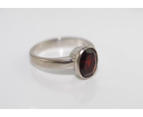 A white gold and garnet ring set in 18ct gold, weighing approx 3.5 grams, size approx H/4, tested as 18ct