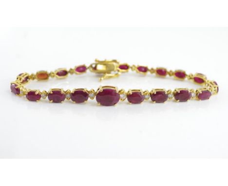 Yellow gold, ruby and diamond tennis bracelet marked 14K with a larger oval centre ruby and alternating diamonds and rubies o