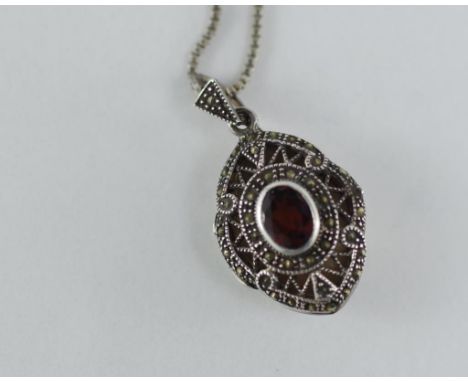 A silver and marcasite locket set with garnet on a silver chain