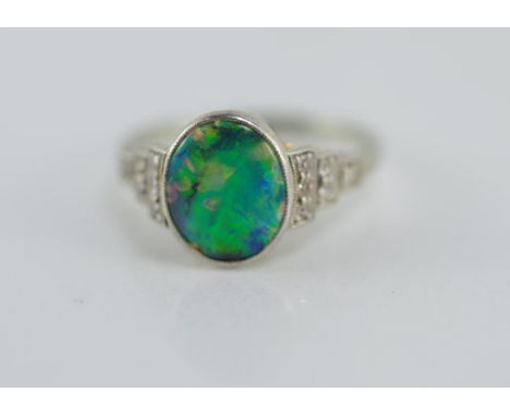 Good platinum and white gold, opal & diamond ring set in 18ct white gold with centre solid oval black crystal opal and 6 sing