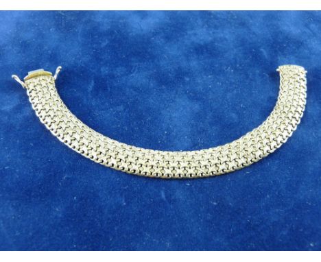 A NINE CARAT GOLD AND DIAMOND WIDE BANGLE of tapered form with pierced oval panels and five small round cut diamonds, 24 grms