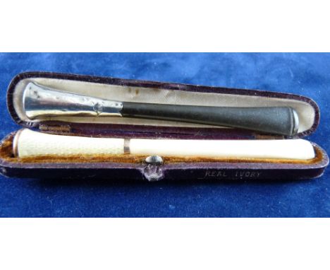 A CASED IVORY AND WHITE ENAMEL CIGARETTE HOLDER and an uncased ebony and silver cigarette holder