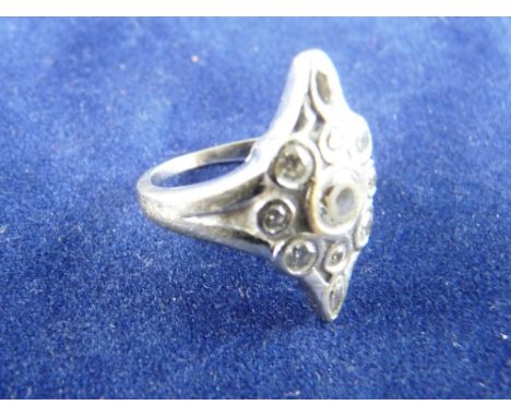 AN EIGHTEEN CARAT WHITE GOLD DIAMOND DRESS RING, mask shaped with centre cz and ten surrounding small diamonds, total 6.7 grm