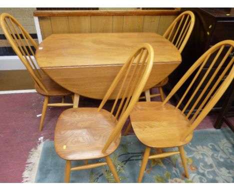 AN ERCOL LIGHT ELM DROP LEAF DINING TABLE AND FOUR CHAIRS having raised hoop with stick backs