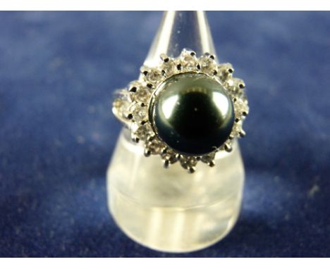 AN EIGHTEEN CARAT WHITE GOLD DRESS RING having a large dark pearl cluster with sixteen surrounding diamonds, each of visual e