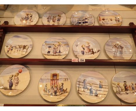 Twelve Royal Worcester collectors plates with wooden wall mounted display unit