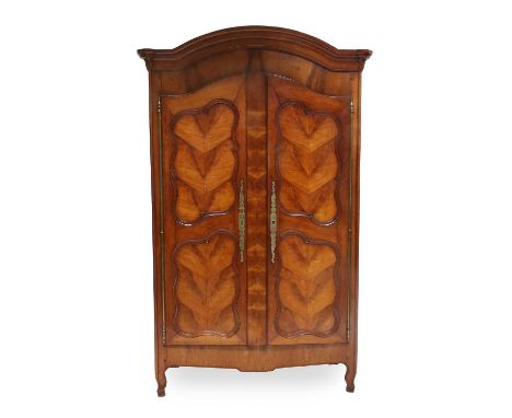 A French Provincial Chestnut and Fruitwood Armoire, 19th century, the moulded cornice above substantial cupboard doors with m