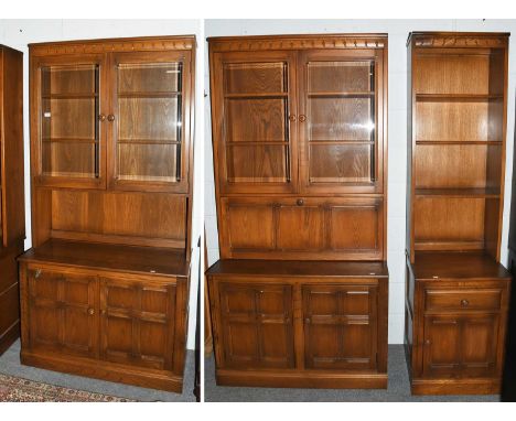 A Modular Ercol Three Part Bookcase, the two larger with glazed upper sections, one having a fall front below, the other a re