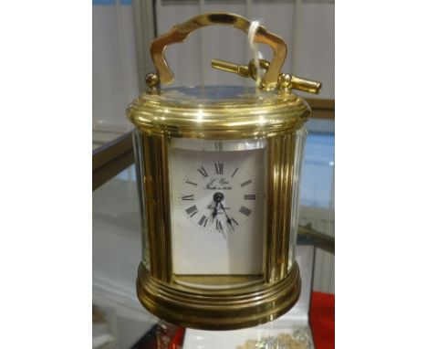 A French miniature oval brass carriage clock, the dial marked 'L'epee' with key, height 11cm, handle up.