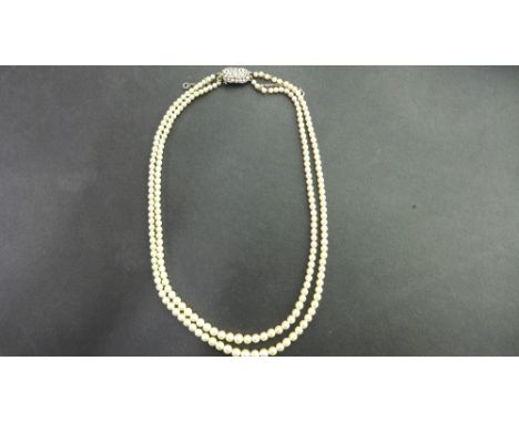 A cultured pearl graduated two-row necklace - To the marcasite clasp - Cultured pearls 3 - 5.5mms - Stamped silver - Length 4