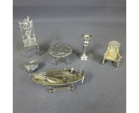 A collection of silver miniatures to include hallmarked Wainscot chair, a Continental chair, an embossed centre table marked 
