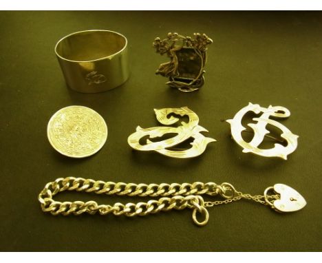 An assortment of items - To include a napkin ring - a miniature frame - a curb-link bracelet - An Aztec brooch - Together wit