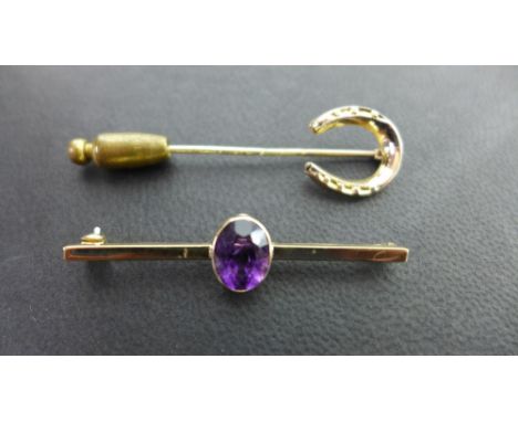 A 9ct gold and amethyst bar brooch, a 9ct gold horseshoe stick pin and a 9ct pink stone stick pin