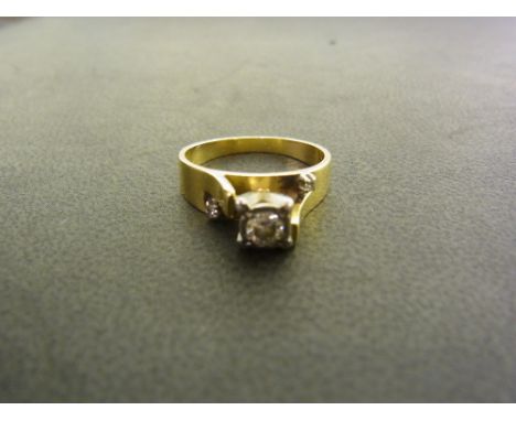 A diamond ring - Of abstract design, the raised brilliant-cut diamond to the asymmetric shoulders set with two further diamon