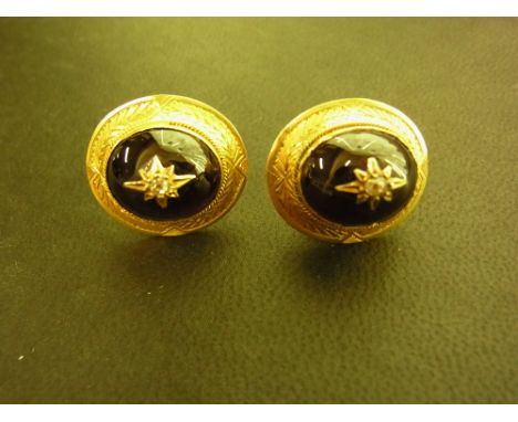 A pair of late 19th/early 20th century gold garnet and diamond earrings - The oval garnet cabochon, inset with a old-cut diam