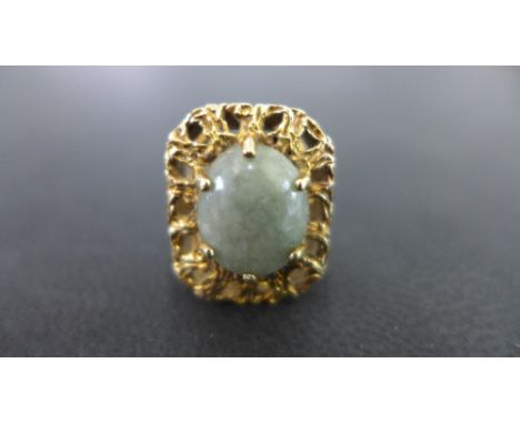 A 9 ct gold dress ring - the rectangular pierced mount set with an oval grey/green stone possibly jade - Weight approx. 5.5 g