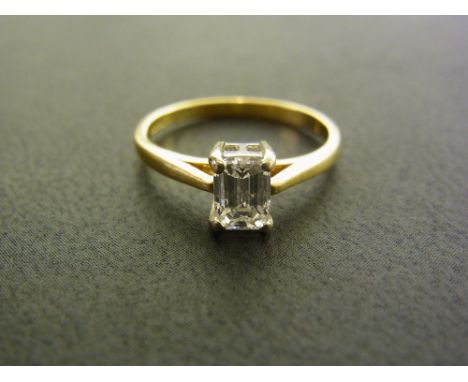 An 18ct gold diamond single-stone ring - The rectangular-shape diamond to the tapered shoulders and plain band - Estimated di