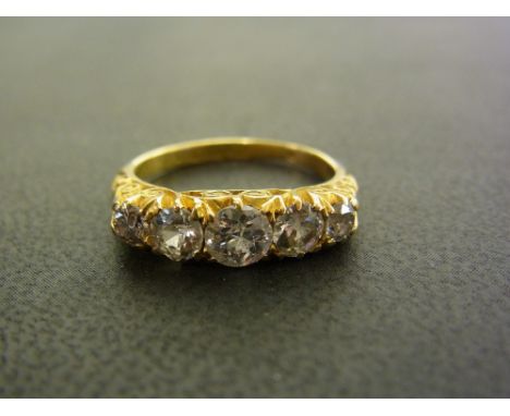 An early 20th century 18ct gold diamond five-stone ring - The graduated old-cut diamonds to the carved gallery and plain band