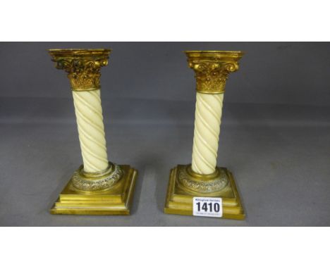 A pair of Victorian gilt brass and ivory candlesticks with Corinthian Captains carved twisted stems and square stepped bases 