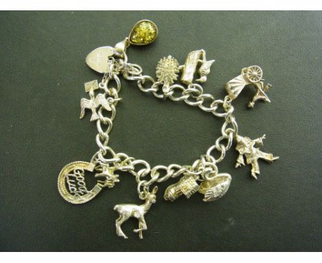 A silver charm bracelet - The curb-link bracelet suspending ten assorted charms, together with a further pendant charm - Hall