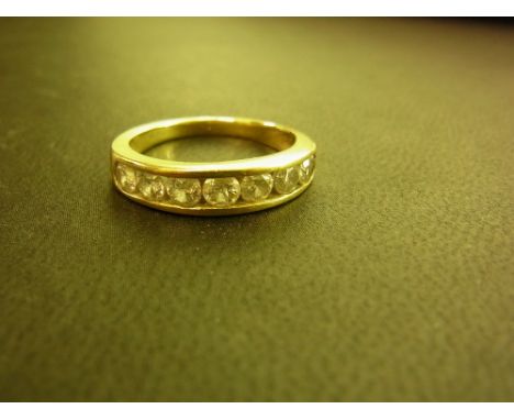 An 18ct gold diamond half-circle ring - The seven brilliant-cut diamonds within a channel setting to the plain band - Estimat