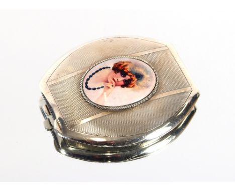 A silver compact, with oval enamel plaque depicting a young lady wearing beads and headdress