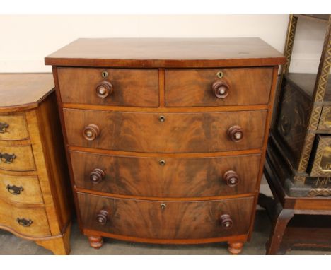 A 19th Century mahogany bow fronted chest, of two short and three long graduated drawers, fitted turned bun handles with moth