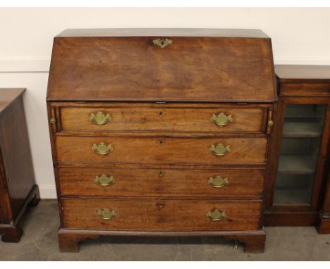 A George III mahogany bureau, the fall front opening to reveal an interior arrangement of drawers and pigeon-holes, four long