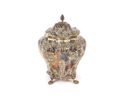 A late Victorian silver tea caddy, of baluster shape with embossed floral and shell decoration, raised on four claw feet, Che