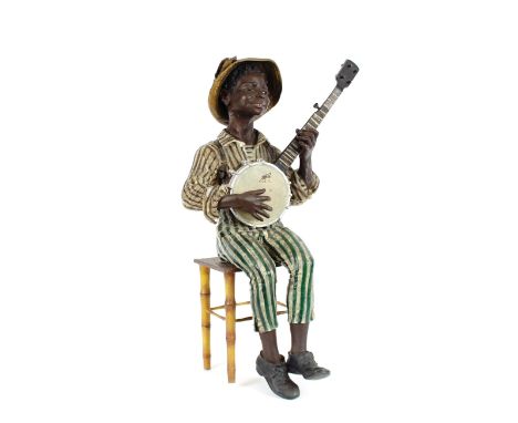A Goldschieder type painted cast metal figure of a banjo playing minstrel, seated on a chair, 64cm high
