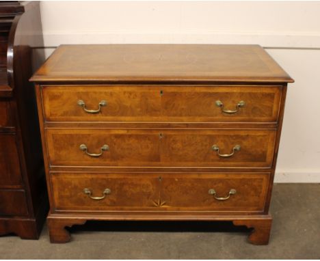 A walnut and inlaid chest, fitted three long graduated drawers, decorated starburst motifs, raised on bracket supports, 111cm