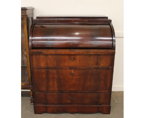 A 19th Century continental mahogany cylinder bureau, the fall front opening to reveal an interior arrangement of drawers arou