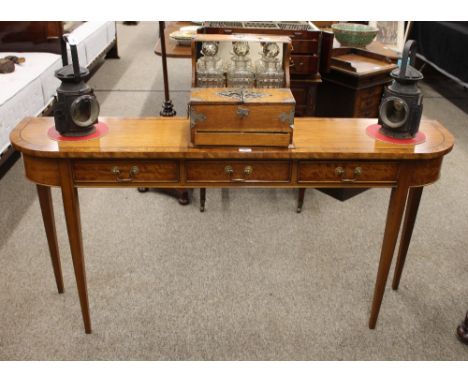 A satinwood bow fronted hall table, fitted three frieze drawers and raised on square tapering supports, 153cm wide