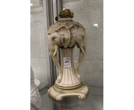 An unusual continental porcelain lamp base modelled as three elephant heads.