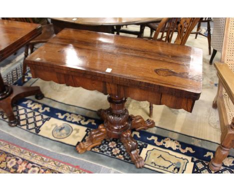 A 19th century rosewood foldover card table on carved column support with four carved legs.