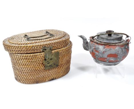 A Chinese red ware teapot, raised with metal mounts of dragons with metal lid in wicker basket, seal mark beneath, (the baske