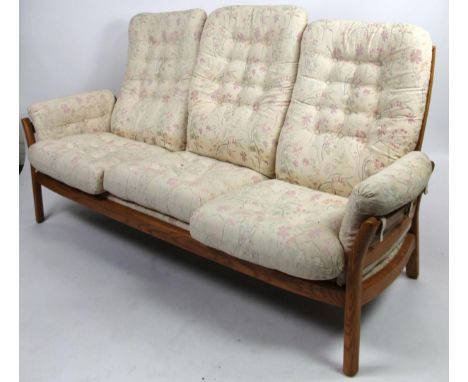 A modern light Ercol three seater cottage settee, with floral cushions on block supports, 188cm wide.