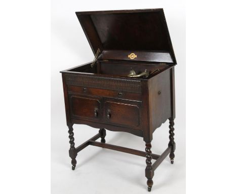 A mid 20thC oak cased freestanding SJD gramophone cabinet, the hinged lid revealing a baize style turntable with articulated 