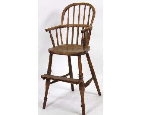 A early 20thC child's ash and elm high chair, with stick back, shaped seat, front leg supports and H stretcher, 89cm high.