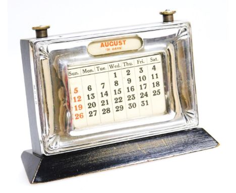 A George V silver fronted desk calendar, with articulated date adjust on a polished wooden stand, Birmingham 1931, 15cm wide.