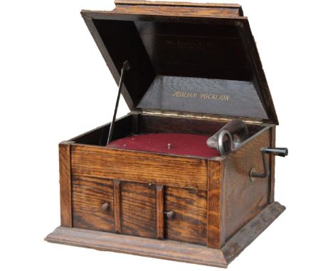 A mid 20thC oak cased gramophone, the square domed box top hinging to reveal a part fitted interior with red baize lined turn