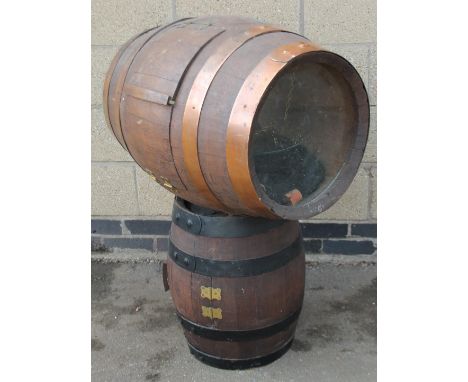 A coopered barrel display cabinet, with hinged opening revealing a glass shelf on a cylindrical barrel stem with copper bandi