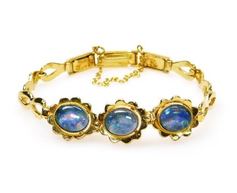 An opal style bracelet, set in floral design, with three opal type stones, on gold coloured bracelet, marked sil. 