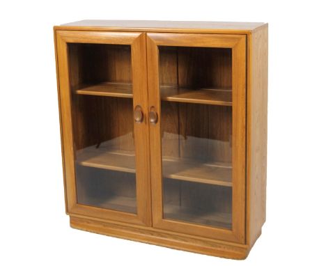 A late 20thC light wood Ercol freestanding bookcase, of rectangular outline with front glazed doors and removable shelves, 10