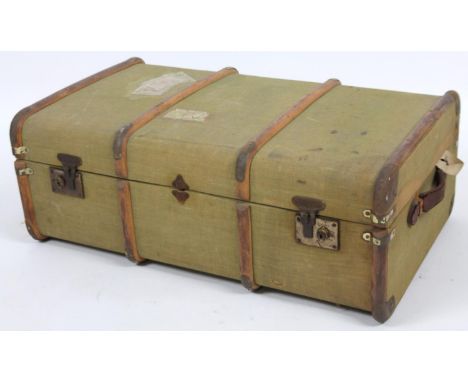 An early 20thC canvas and part wooden bound travel trunk, of rectangular outline with leather side handles and several luggag