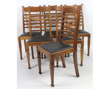 A set of Edwardian oak ladder back dining chairs, with shaped part pierced backs, square tapering wood supports and drop in s