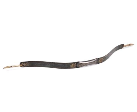 A shaped (arrow) bow, unmarked metal, heavily textured, decorated with a repeat geometric floral pattern, flowerheads, scroll