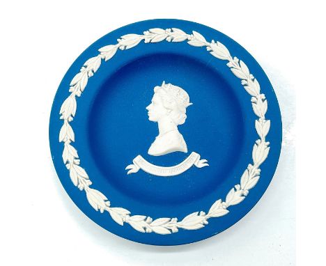 Small round dish with dark blue matte finish; white foliate designs with profile portrait of Queen Elizabeth in relief.Made i